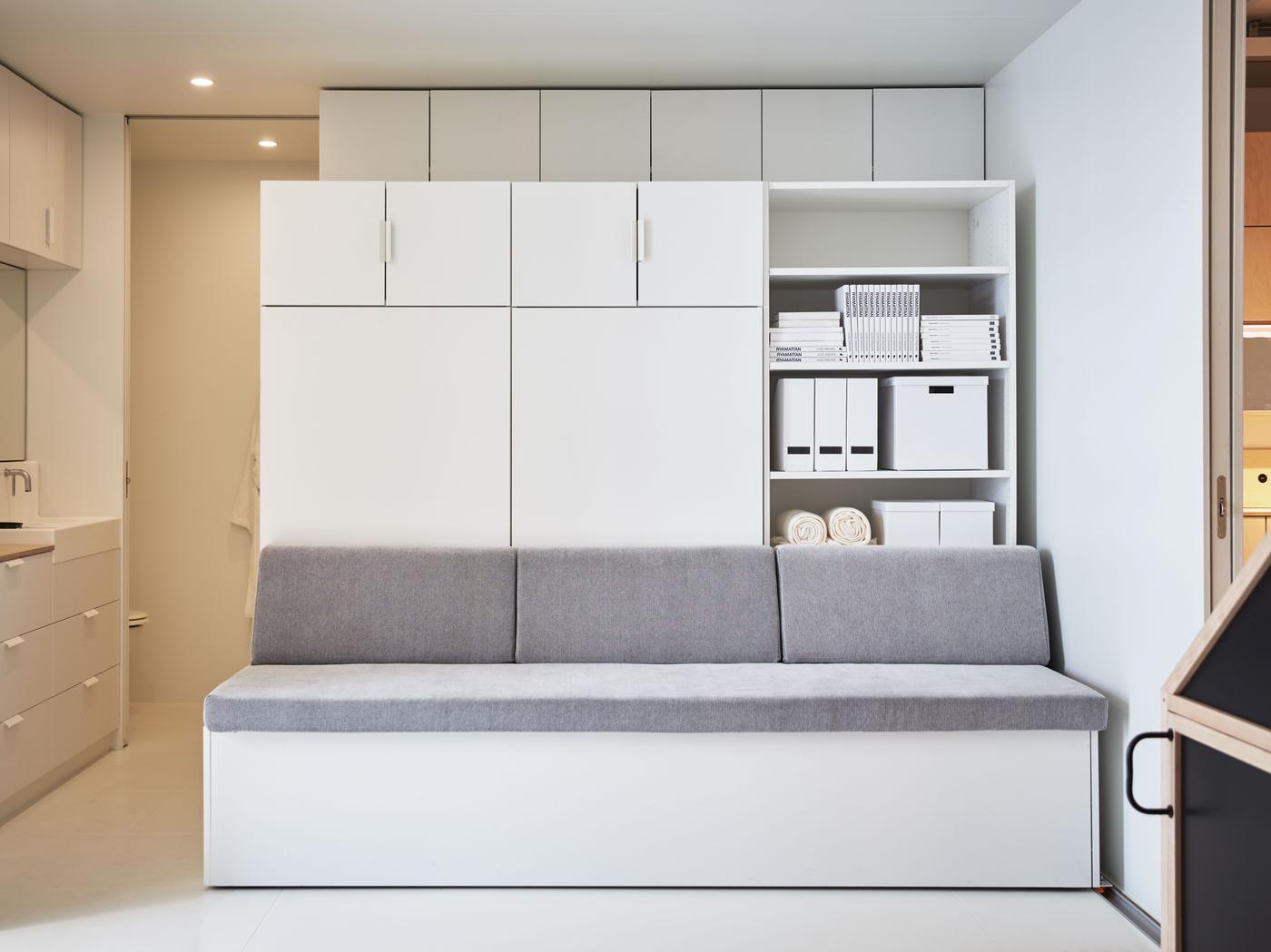 A robotic sofa and storage unit in a small living space.