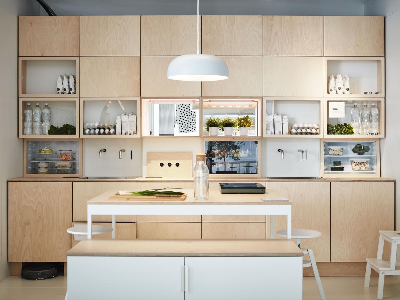 Compact kitchen and dining area with light wood fronts and a mix of open and closed overhead cabinets.