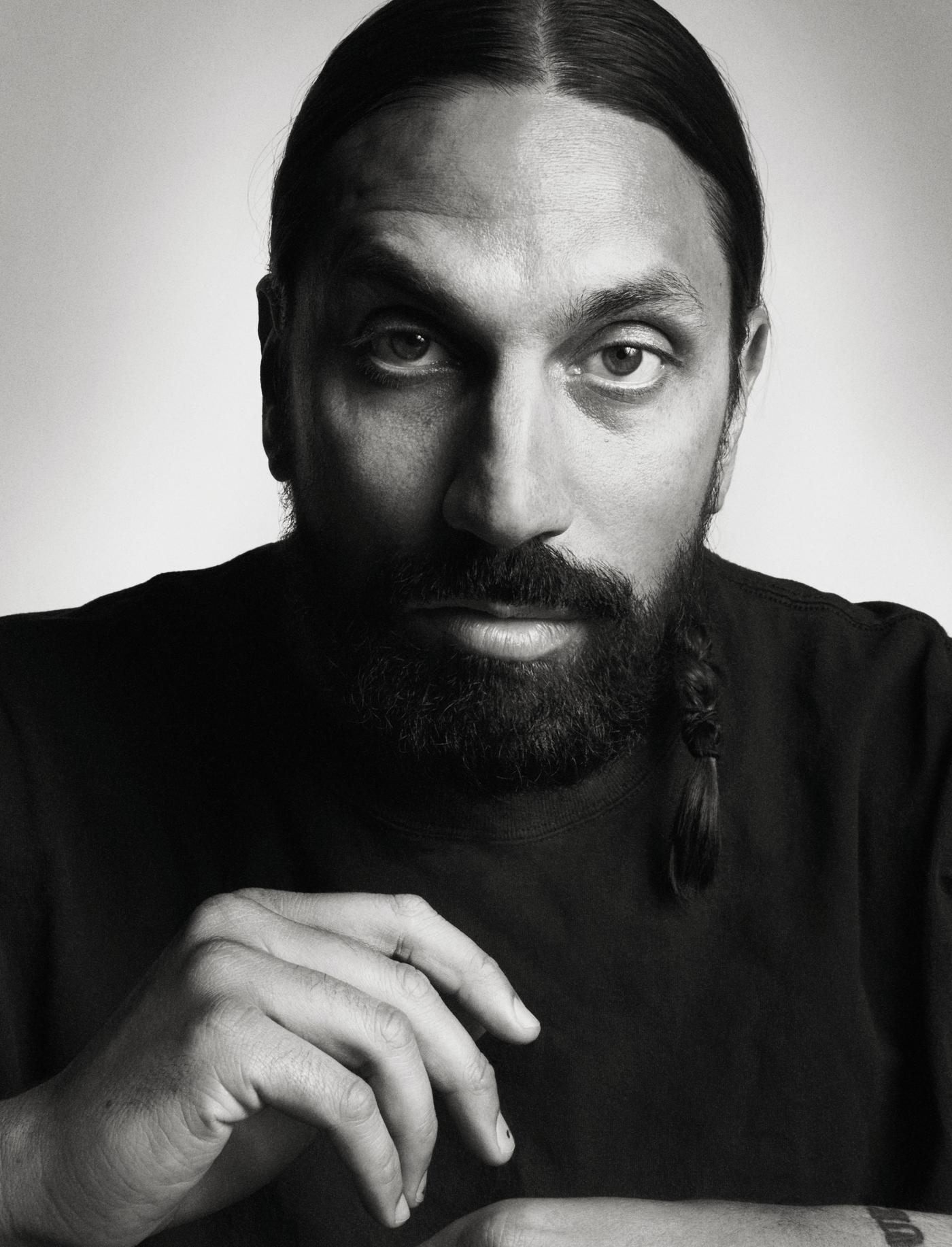 A black and white portrait of a man with a beard.