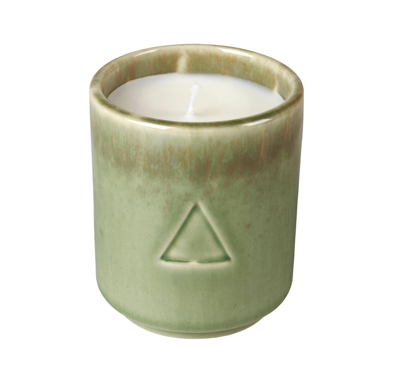 A green ceramic handle holder with a candle inside. Against a white background.