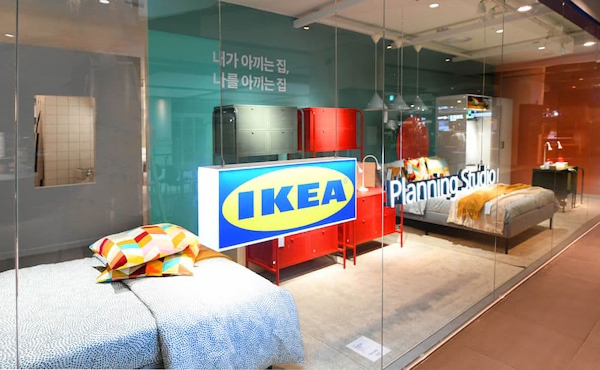 An IKEA planning studio with glass doors. There are beds and storage units behind the glass doors.