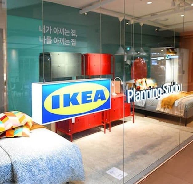 An IKEA planning studio with glass doors. There are beds and storage units behind the glass doors.