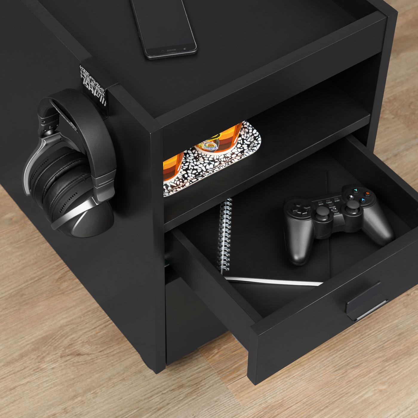 A black unit on castors. The draw is open revealing gaming controls. Headphones hang on the side.