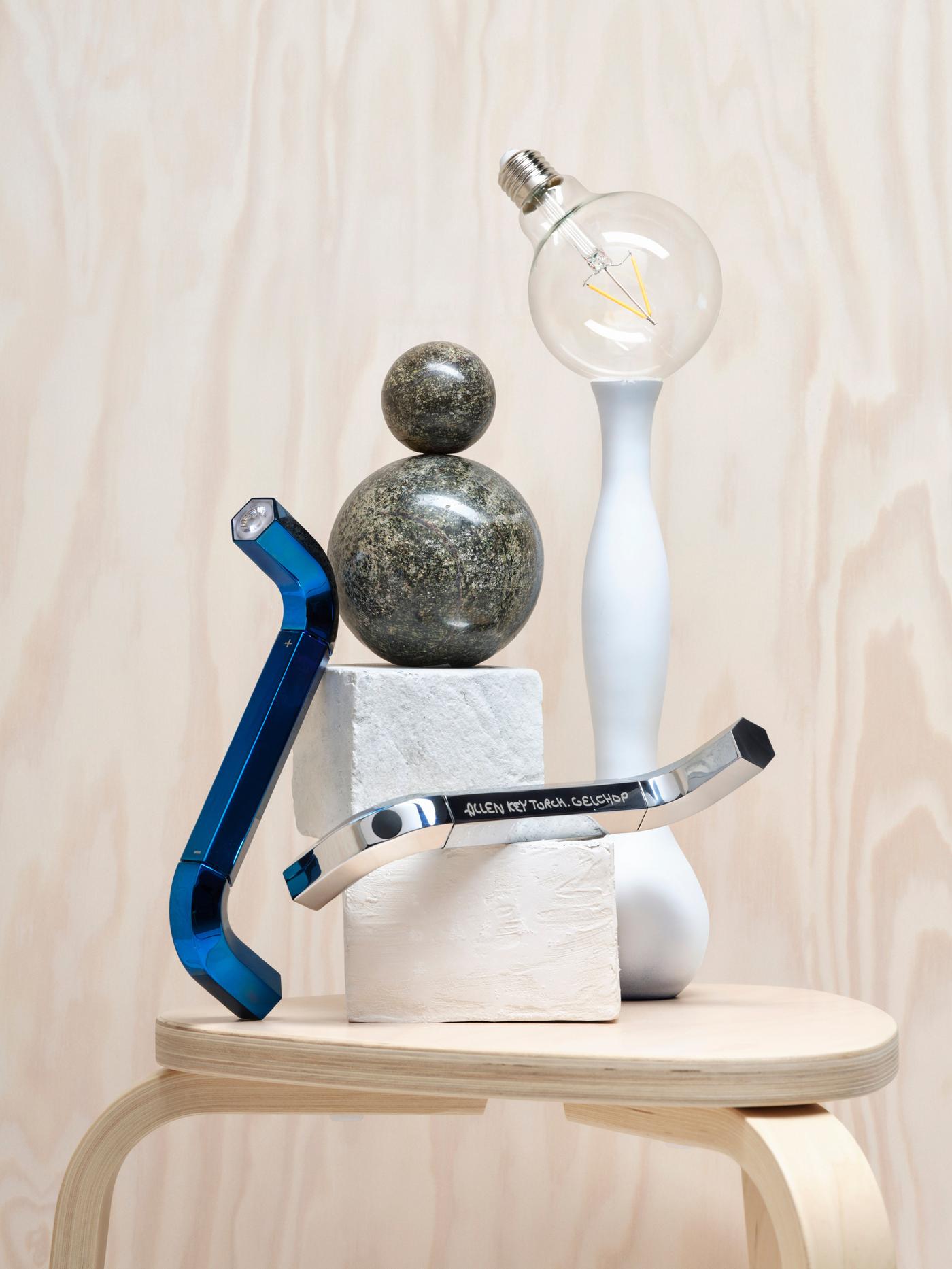 A collection of allen key torches, blocks and stone circles are stacked on a wooden stool. 