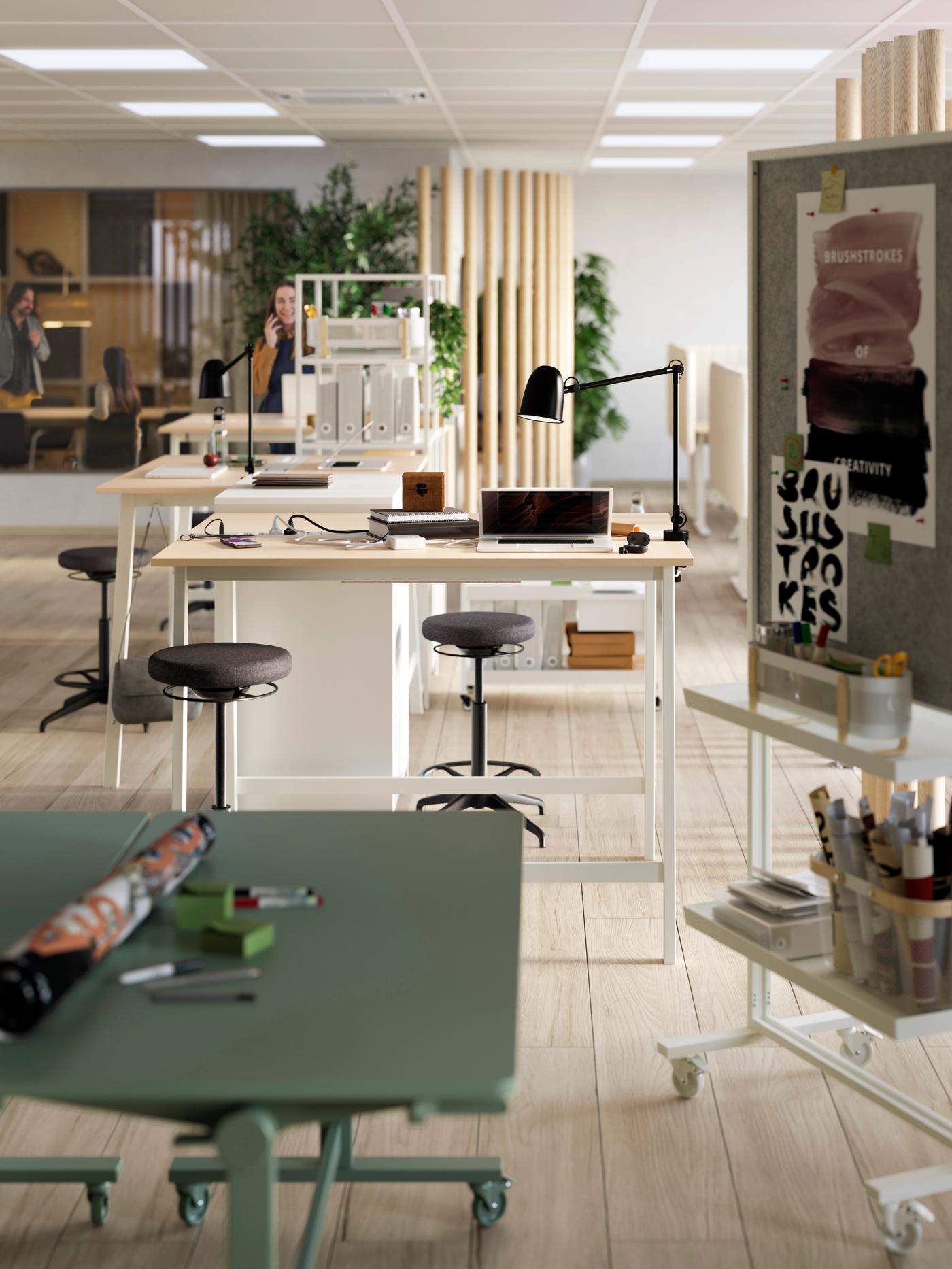 Office space with different working spaces. Desks and stools in different colors, showing a versatile work space. 