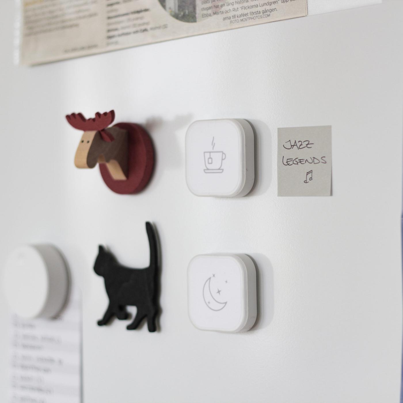 A wall with animal decorations and two TRÅDLÖS remote controls with stickers.