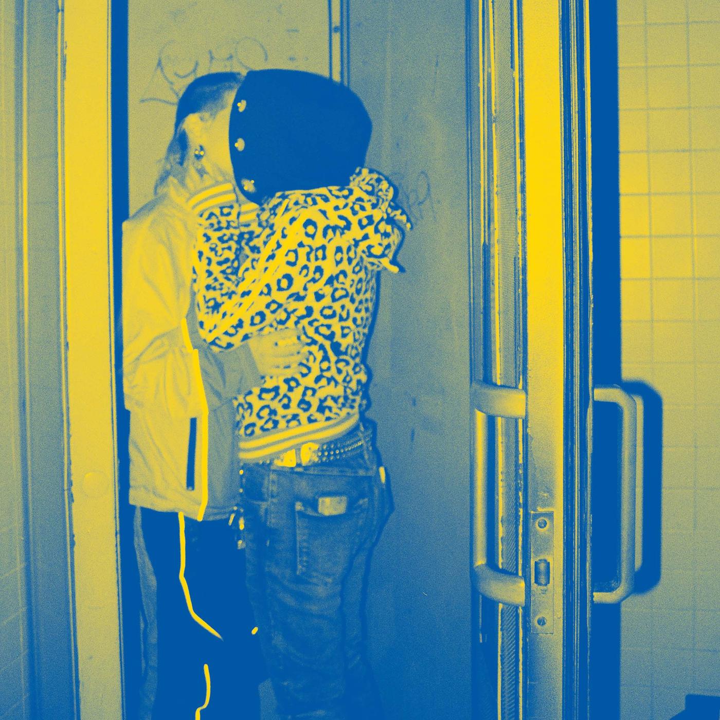 Two people holding each other close while kissing in an elevator.