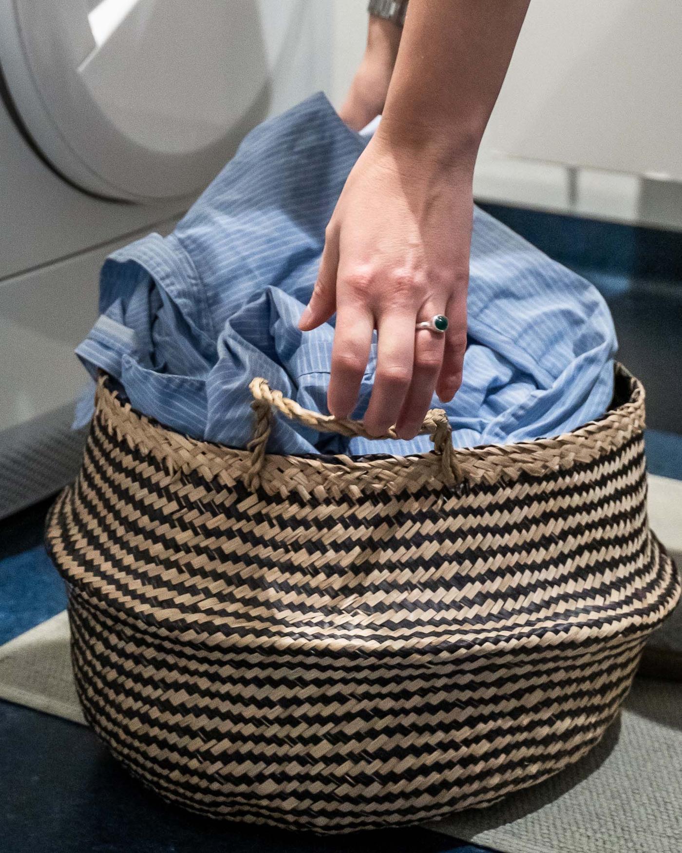 A basket of laundry in a blue and white laundry room.