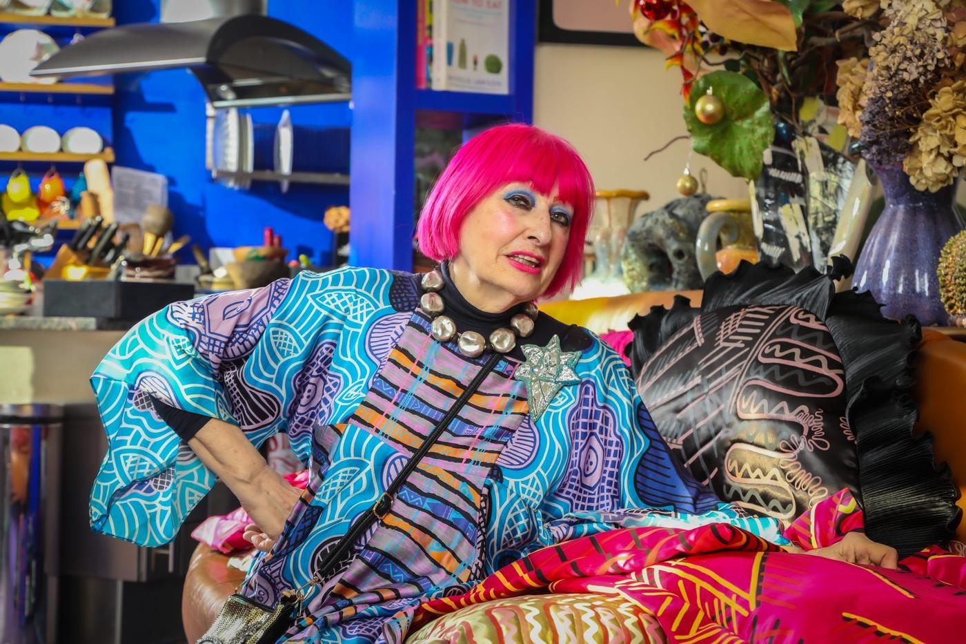 Zandra Rhodes posing with eclectic cushions.