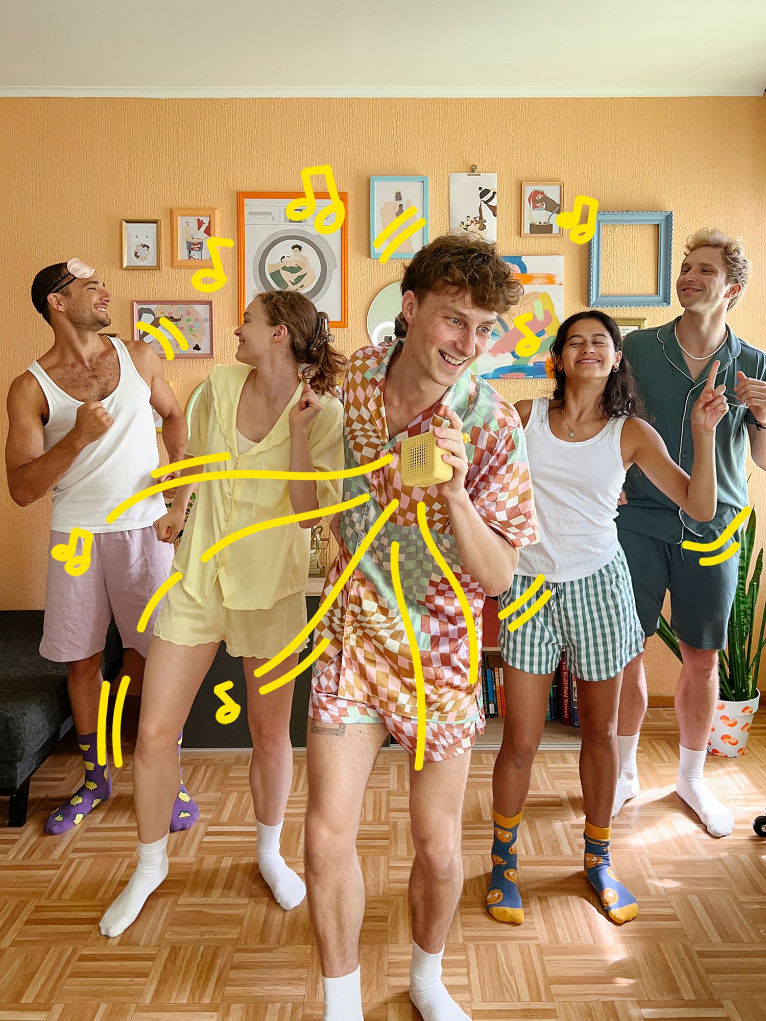 A group of friends dancing together in a living room with a VAPPEBY portable bluetooth speaker.