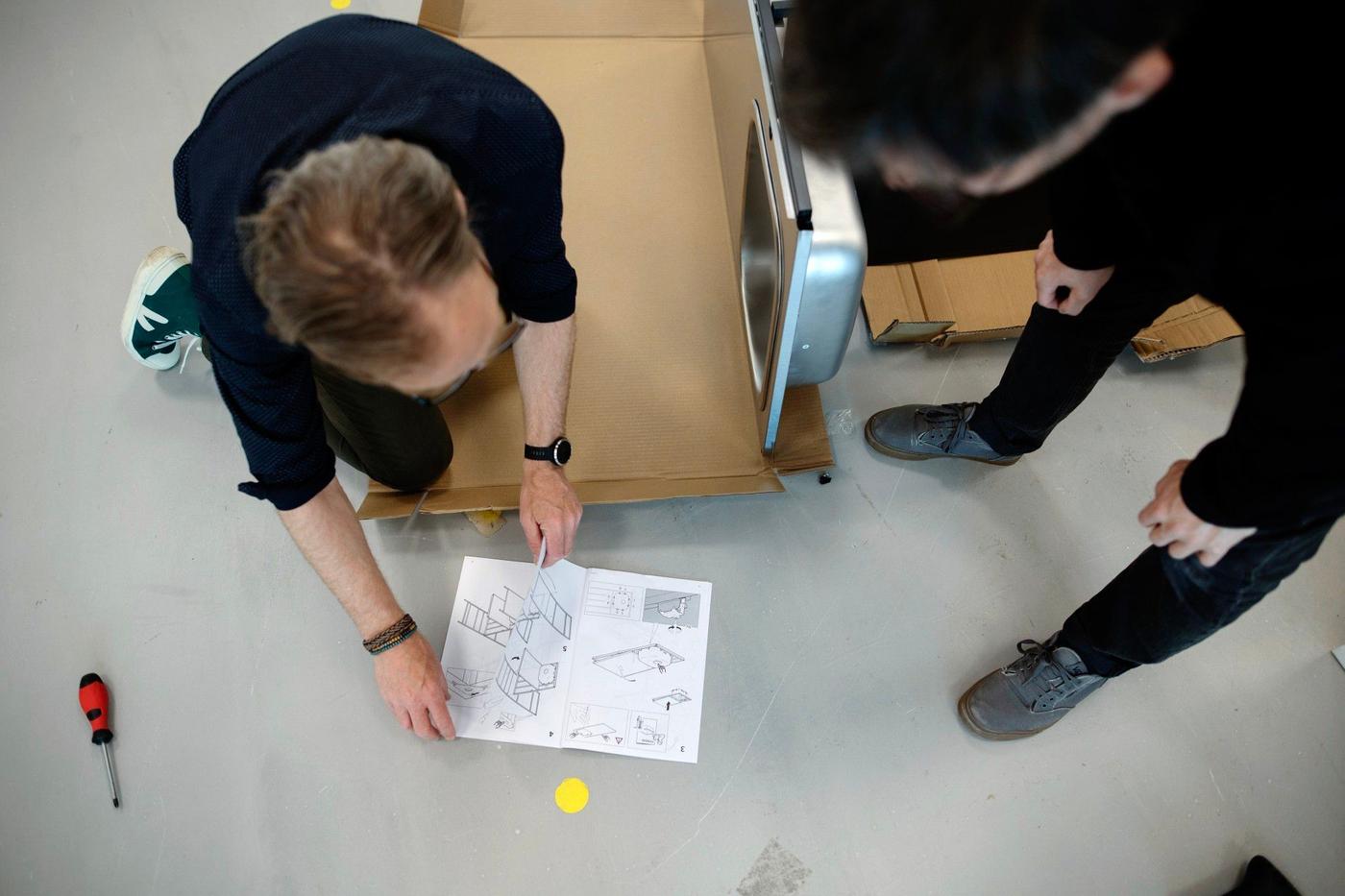 Two men assembling an IKEA kitchen.