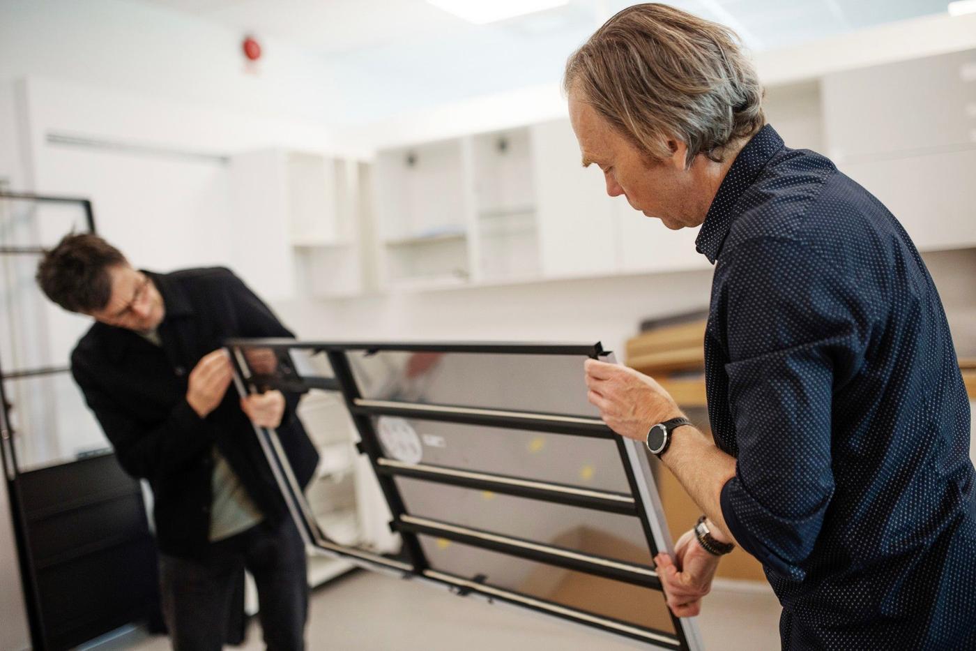 Two men assembling an IKEA kitchen.