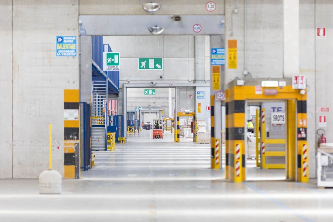 Interior view of a large, brightly-lit production facility with several adjoining rooms connected by large doorways.