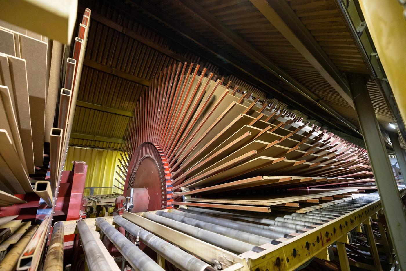 Particle boards lying on a rack in an industrial environment.