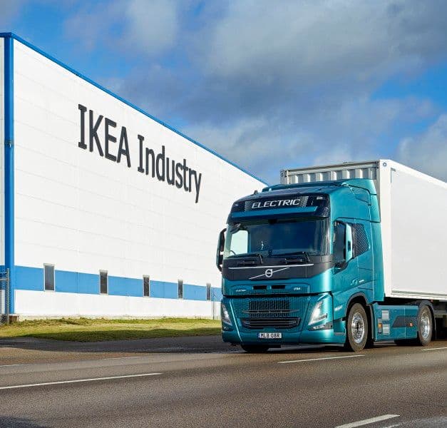 A blue truck passing an IKEA Industry building.