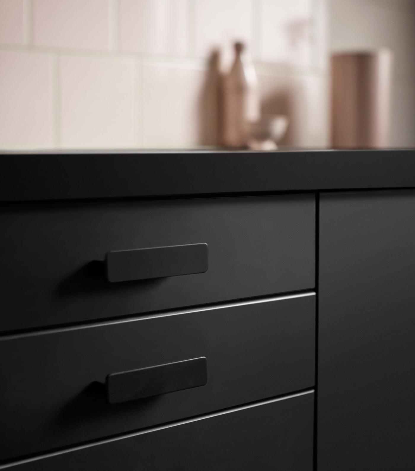 Dark-fronted drawers and cabinets beneath a dark kitchen worktop.