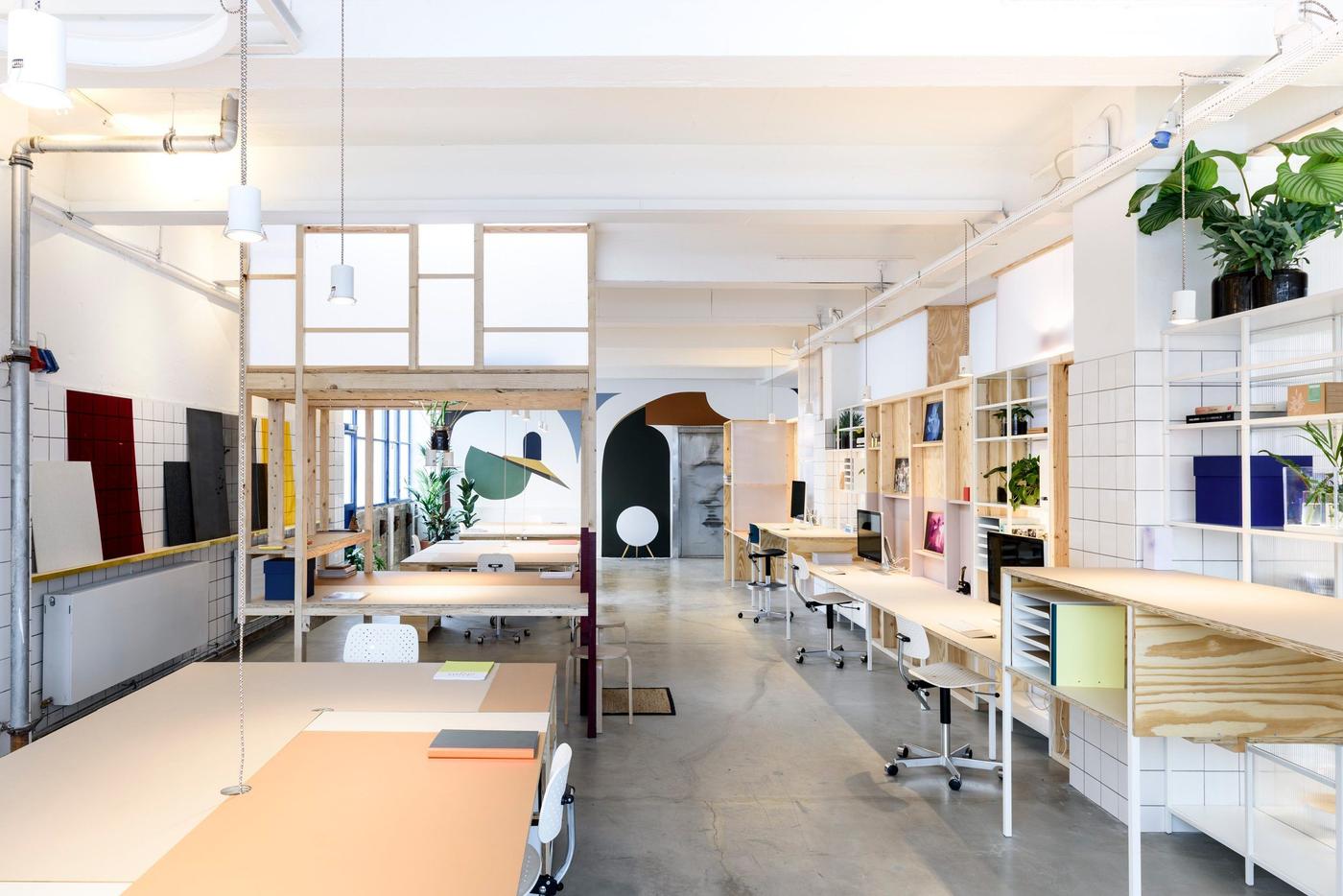 A room filled with different types of tables, desks, shelving and chairs.