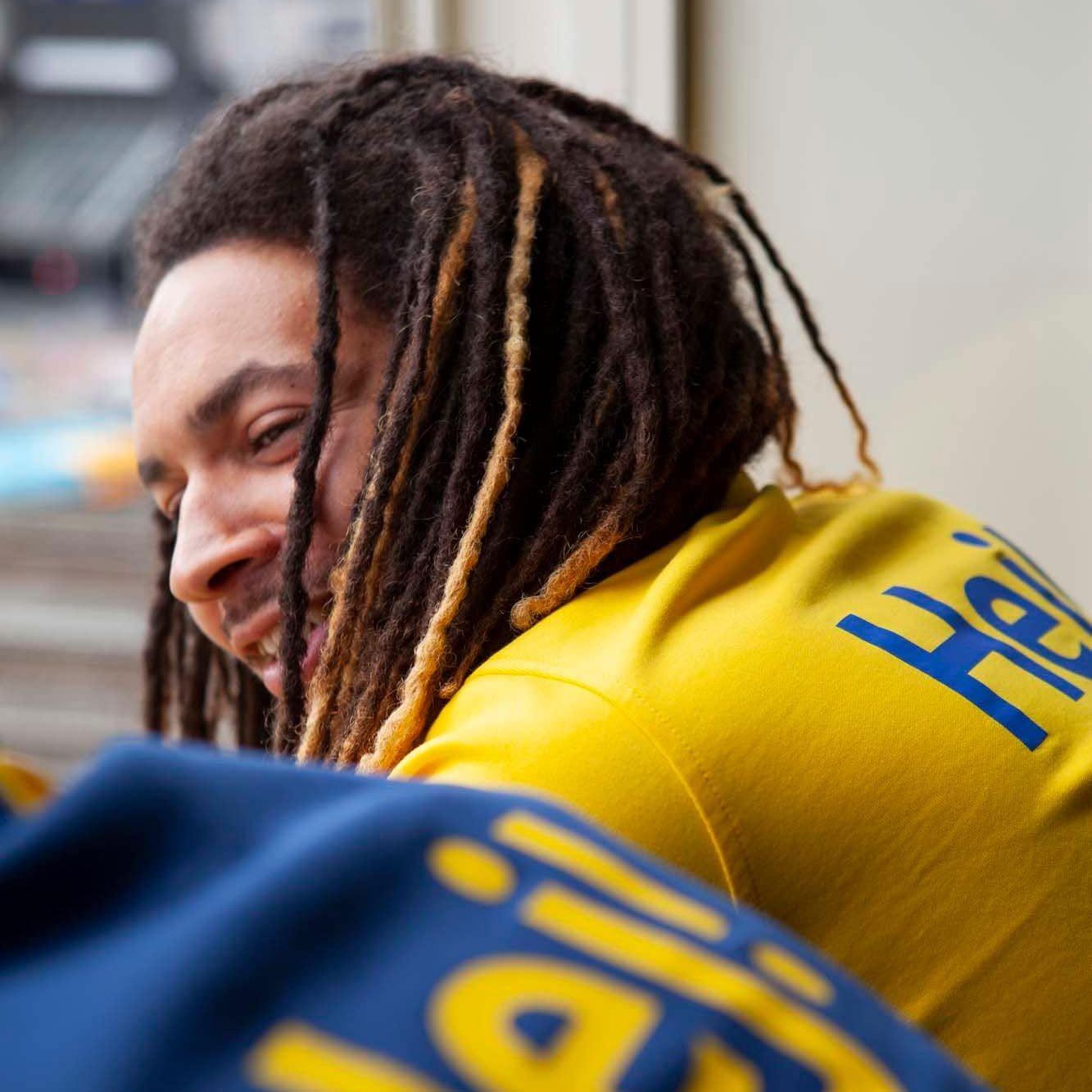 An IKEA co-worker wearing a yellow t-shirt that says "Hej!" on the back.