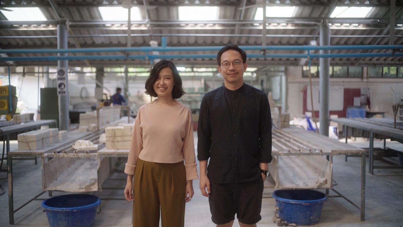 A man and a woman inside a ceramic workshop.