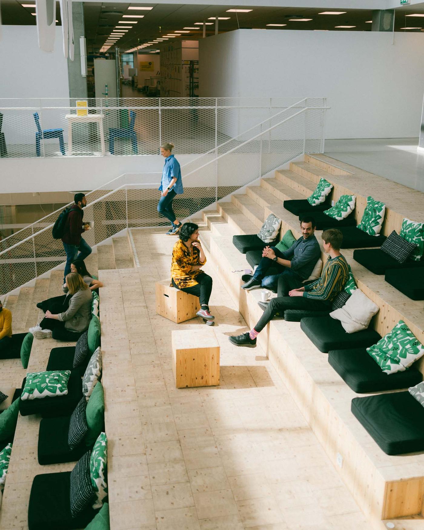 People sit on seats in a large public area.