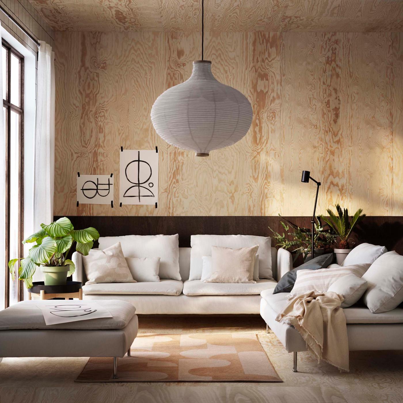 The SÖDERHAMN sofa series in a modern living room with black and wood walls.