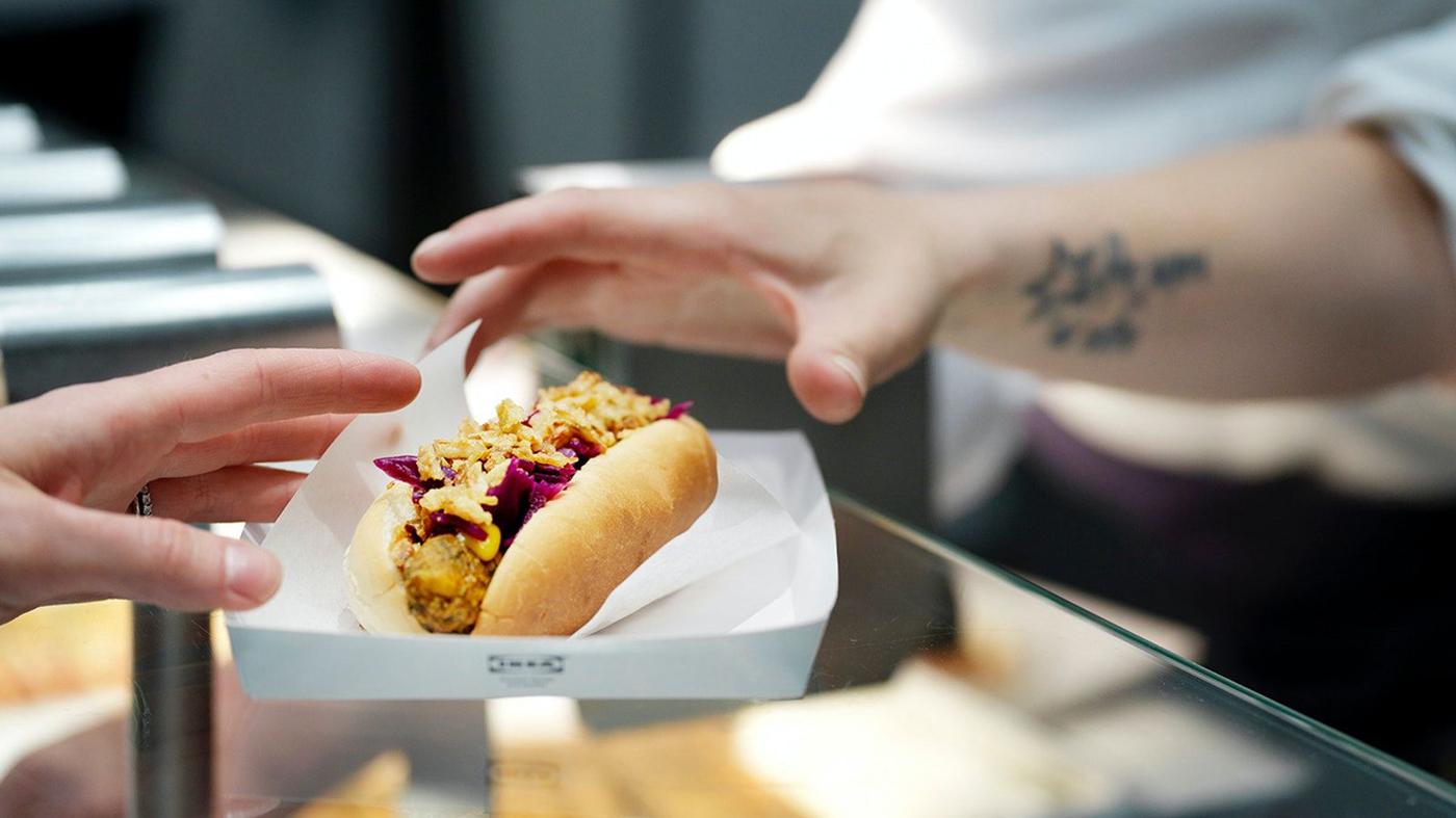 A veggie hot dog changing hands in the IKEA store.