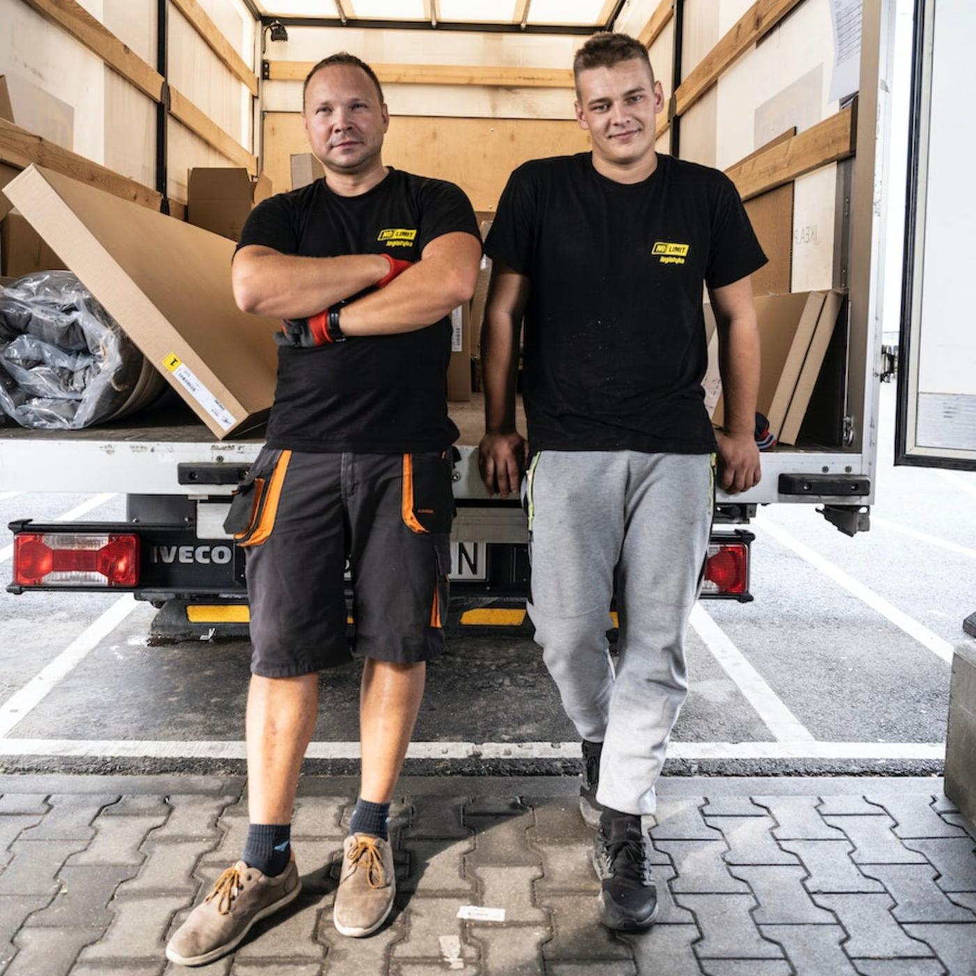 Two men standing at the back of a delivery truck.