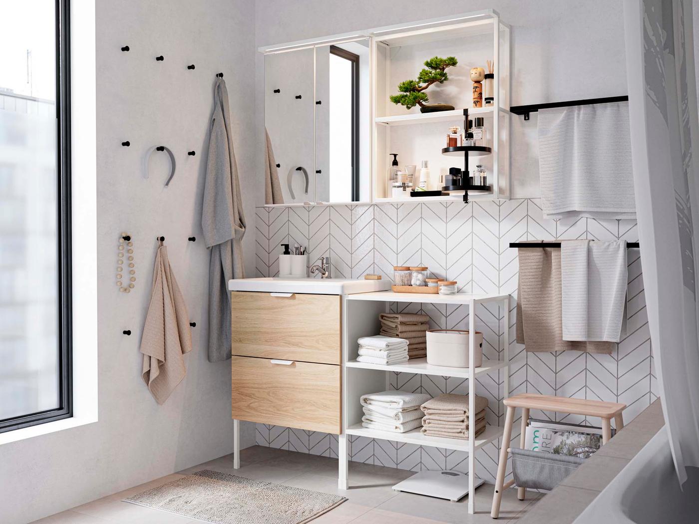A bathroom corner with rows of black hooks on one wall and a white and wood vanity unit on the other.