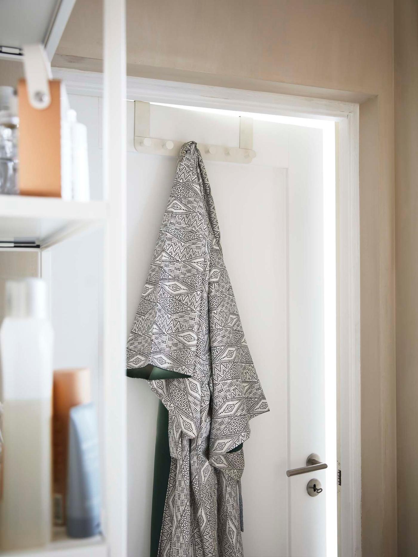 A robe hangs from an ENUDDEN over the door hook in the bathroom.