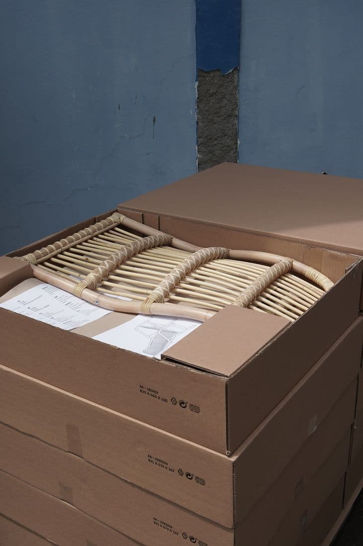 A SALNÖ armchair flatpacked in an open cardboard box.