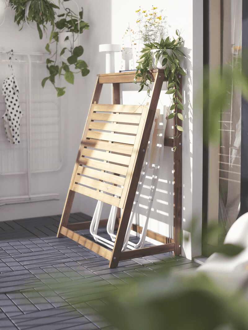 A sunny, outdoor area with a brown DJUPÖN folding table, folding open and closed.
