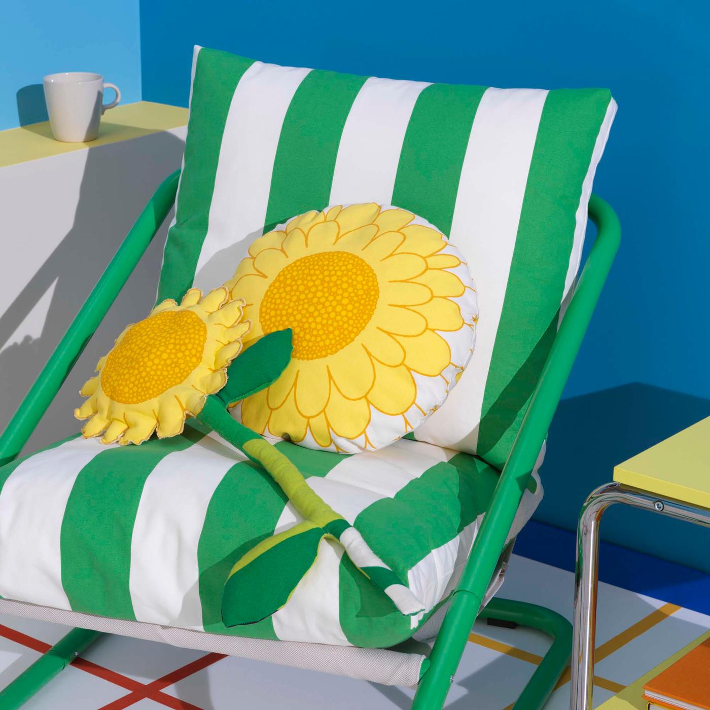 A green and white chair with a yellow fabric sunflower and sunflower cushion.