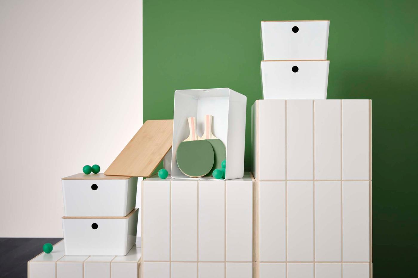 White KUGGIS storage boxes are stacked on top of white folders.