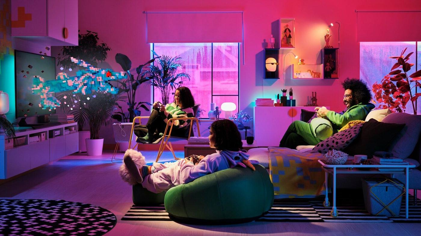 A family sitting in a brightly coloured room, gaming together.