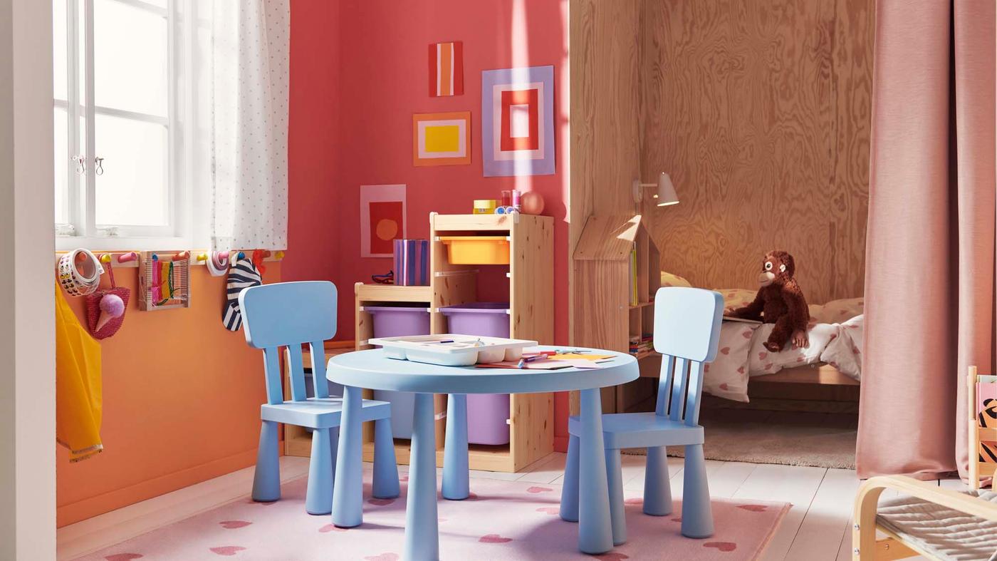 A children's play area with a blue MAMMUT table and two chairs.