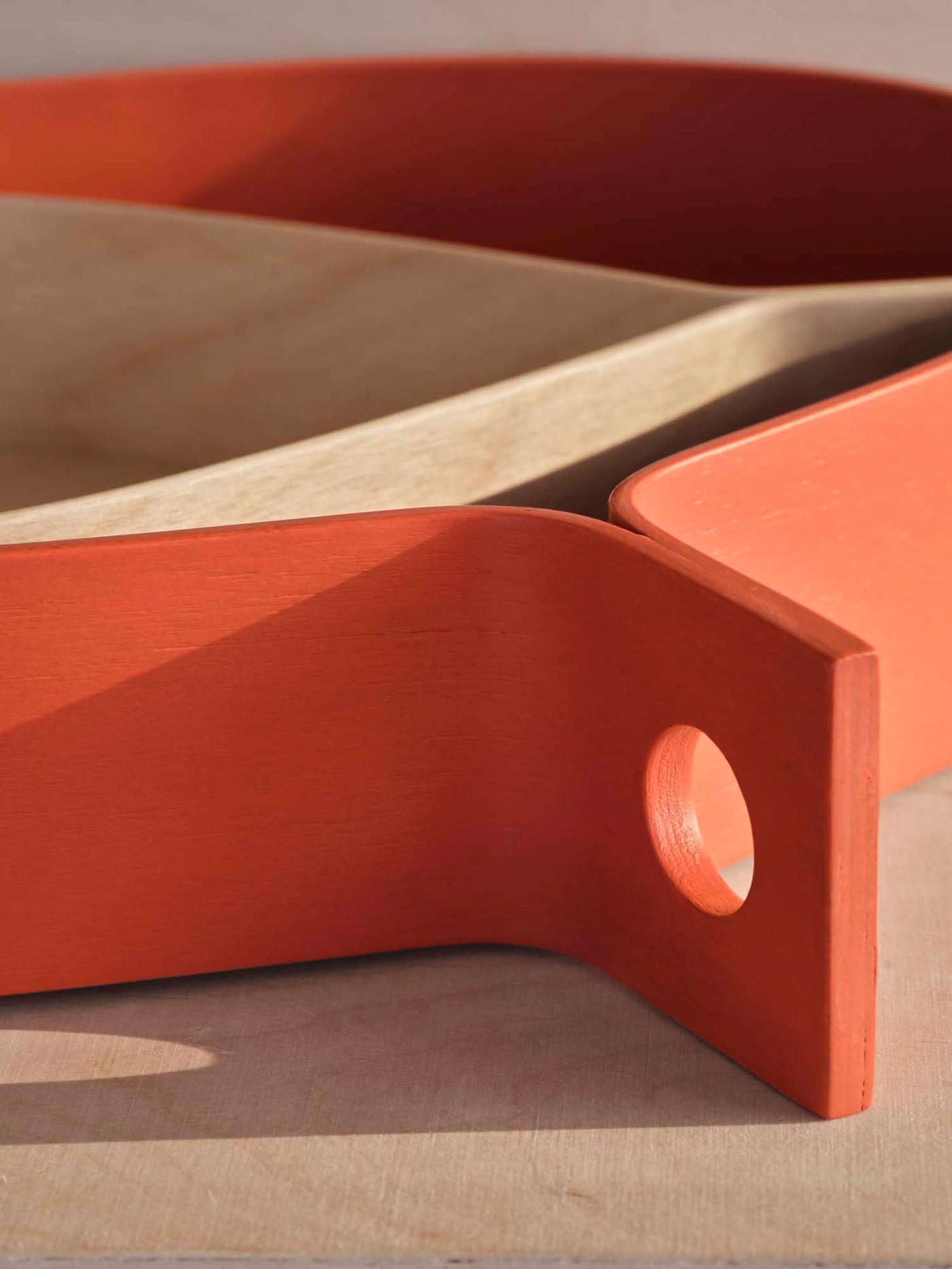 A close-up of the handle of an orange OMMJÄNGE tray.