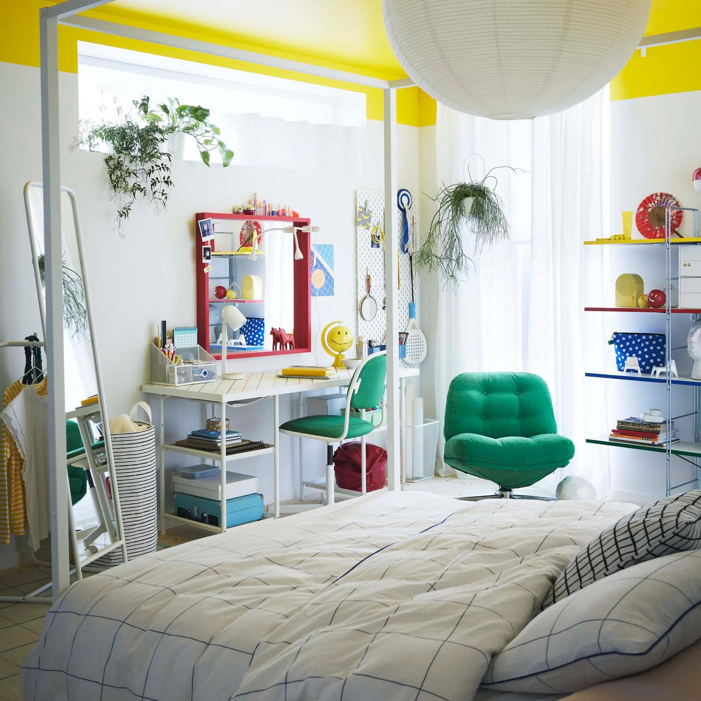 A white walled bedroom with a bright yellow ceiling and primary coloured furniture and accessories.