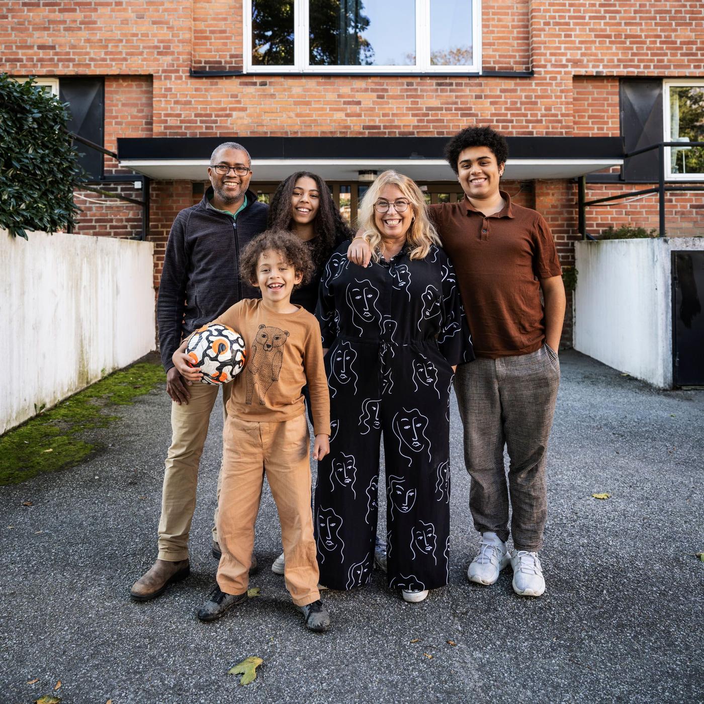Portrait of Cecilia and Cédric's family, standing outside their apartment block.