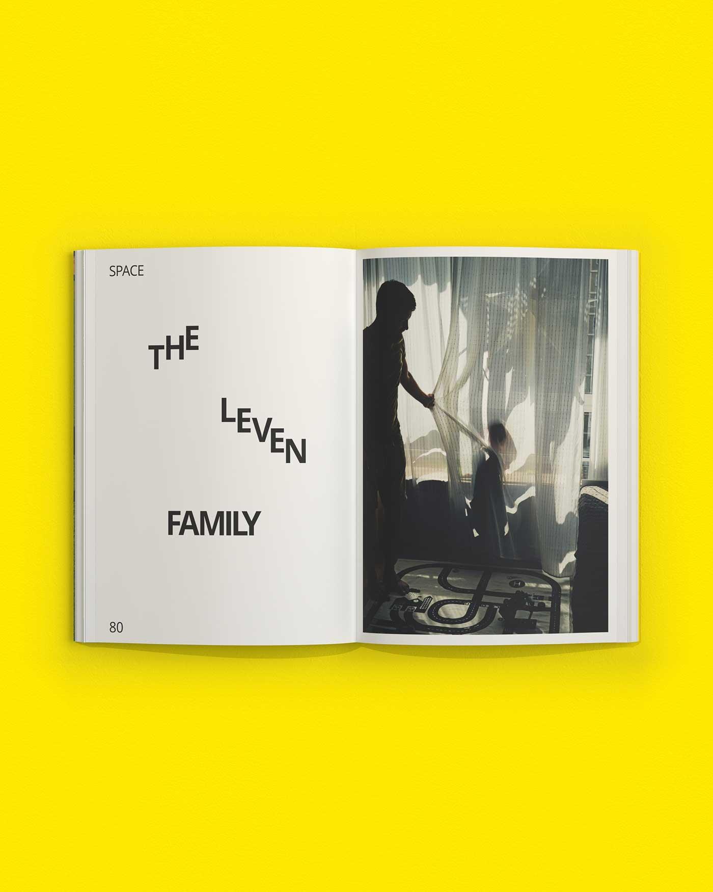 An open copy of Us & our planet on a yellow background, showing a family at home.