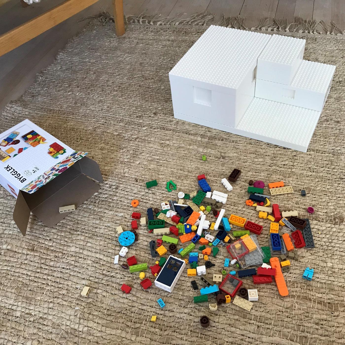 White BYGGLEK LEGO boxes, a cardboard packaging box and brick set on a rug.