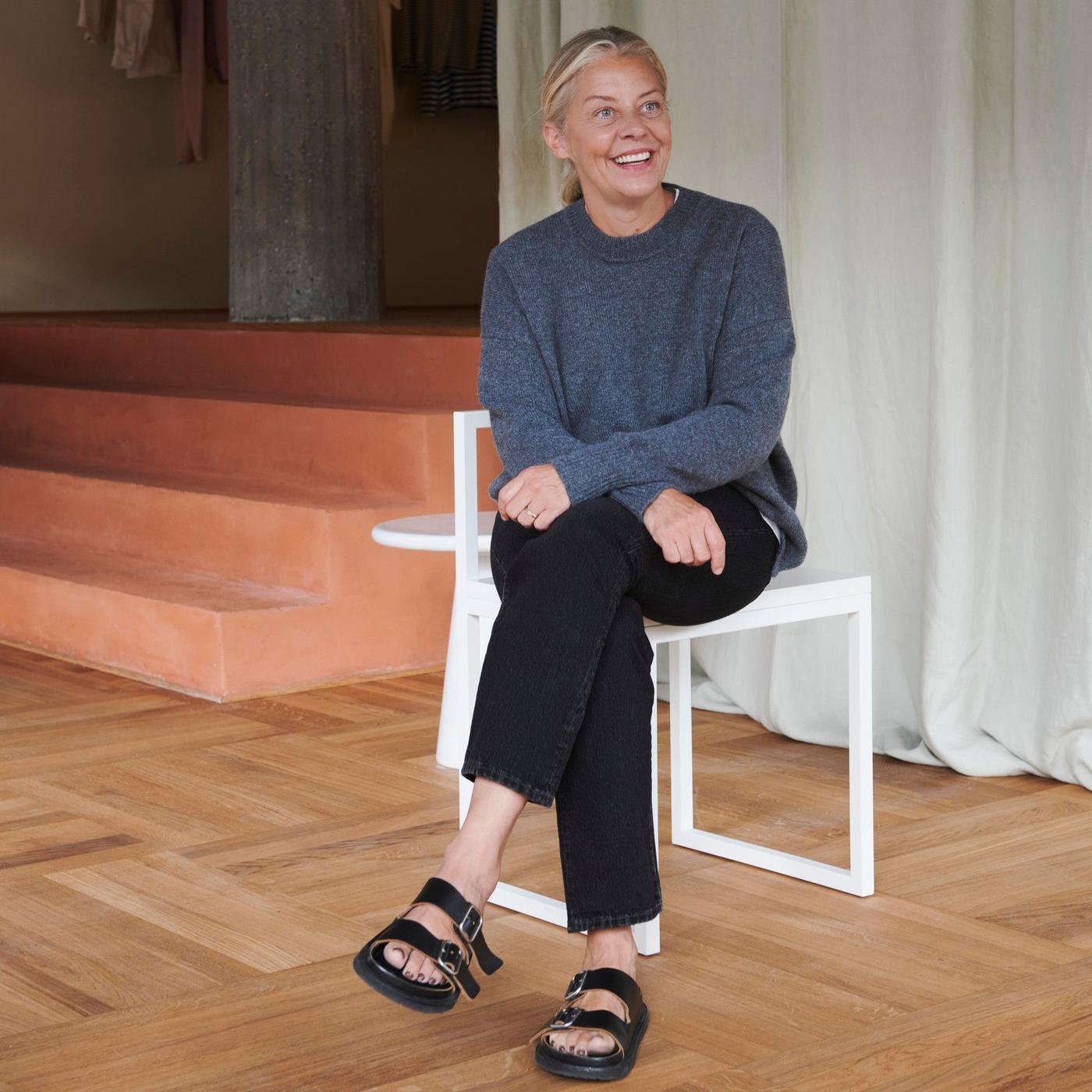 A woman sitting on a chair in the middle of a room