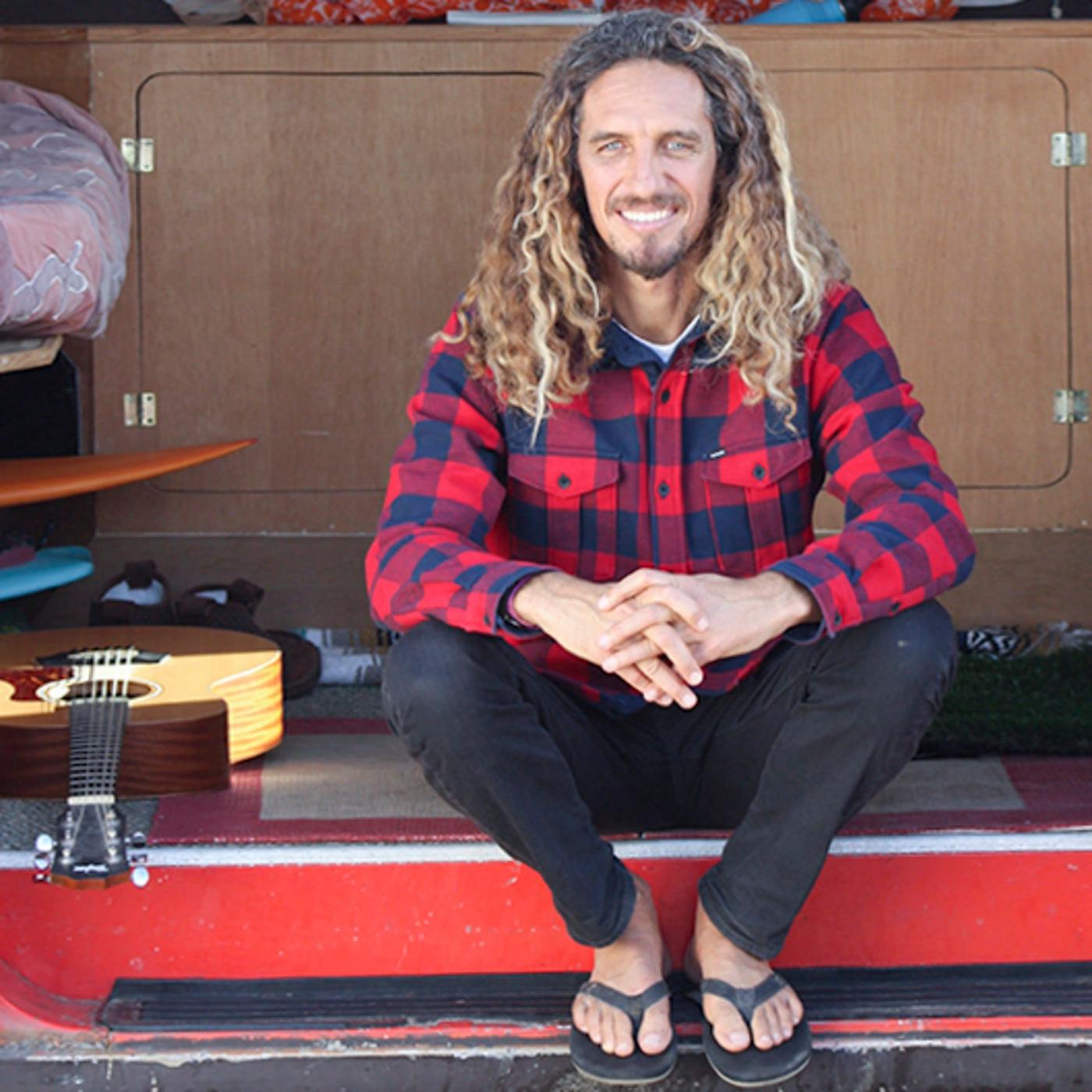 A man in a red and black checkered shirt sitting in the back of a van