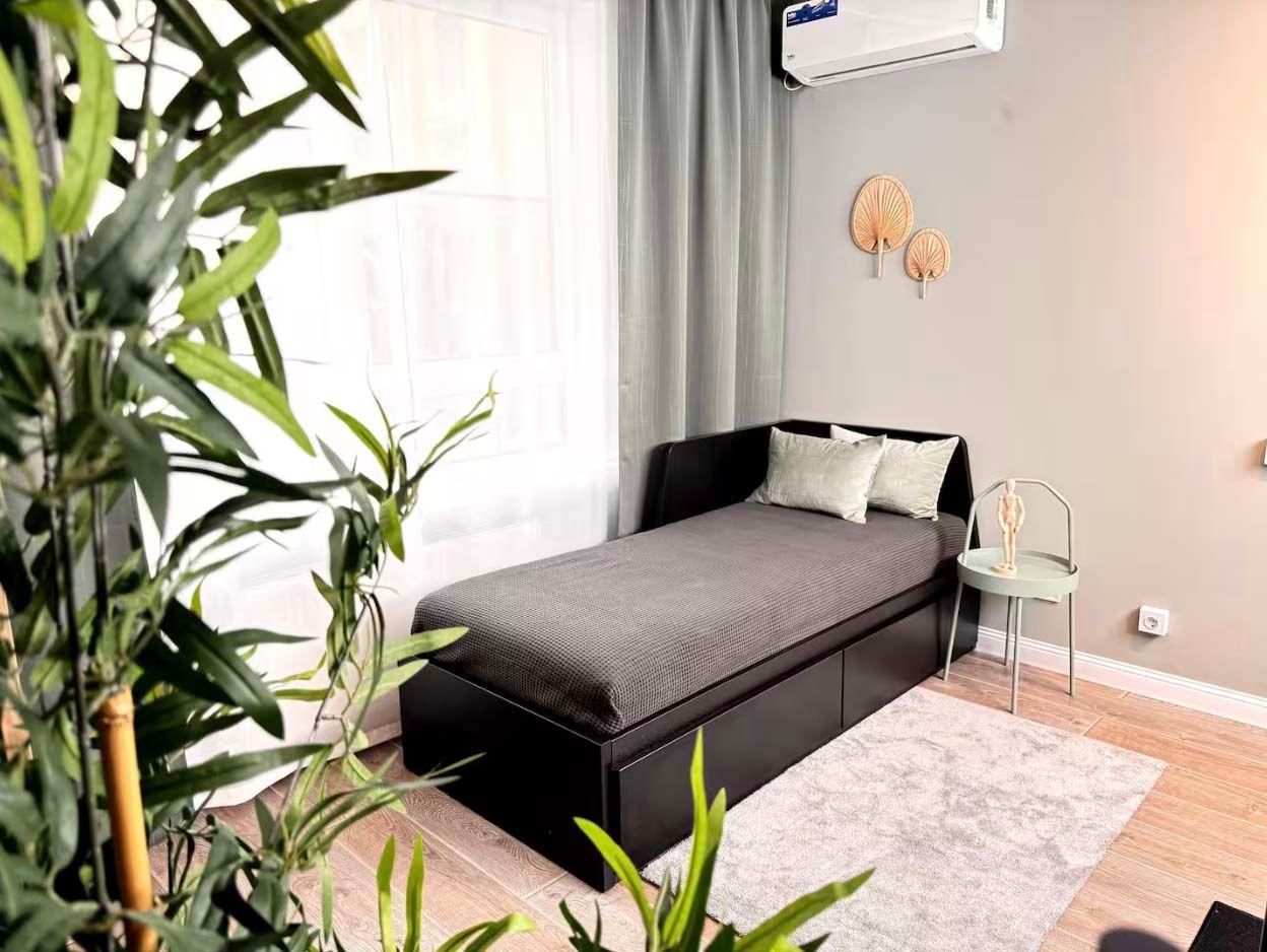 A living area with a single bed in the Stylish Design Apartments Airbnb in Almaty, Kazakhstan.