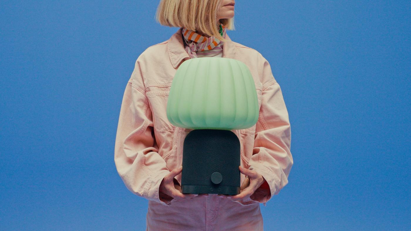 Close-up of Tekla Severin holding a green lamp in her arms, facing sideways.