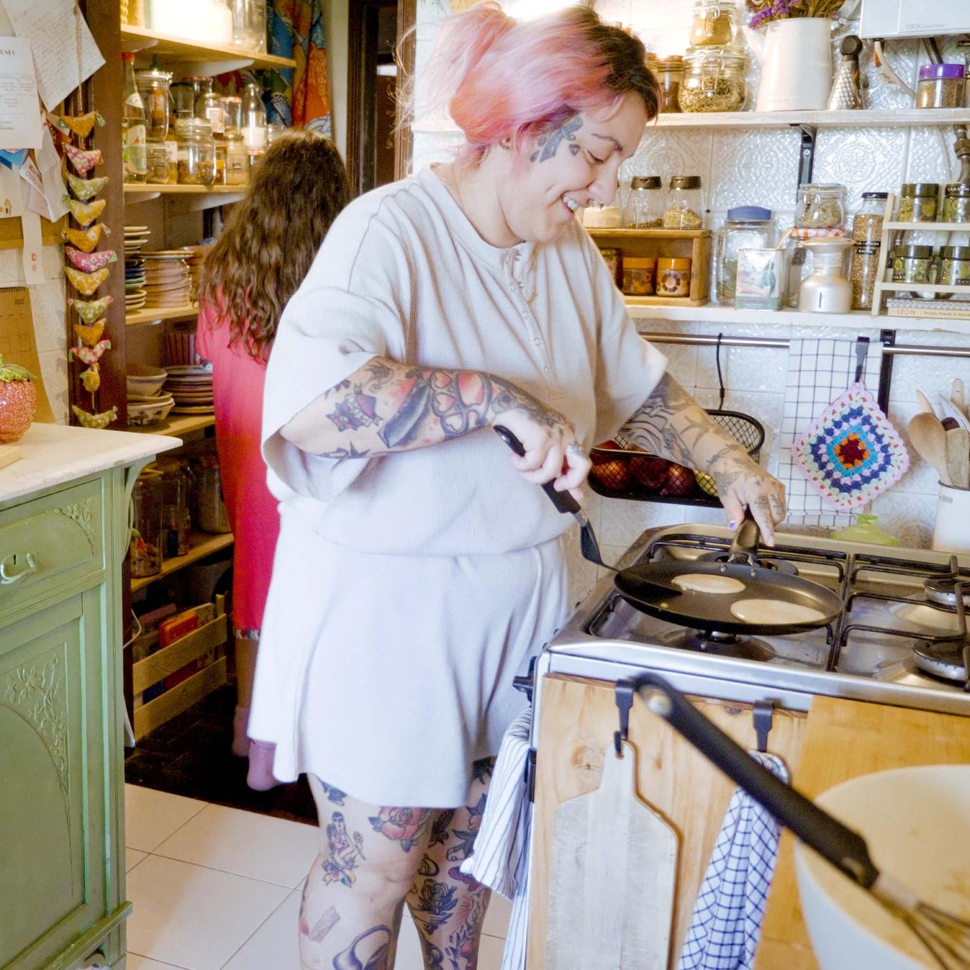 Denise is making pancakes in the kitchen. She is smiling
