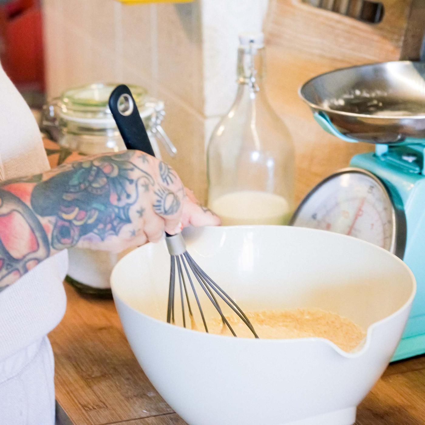 Denise mixes pancake batter in a bowl.