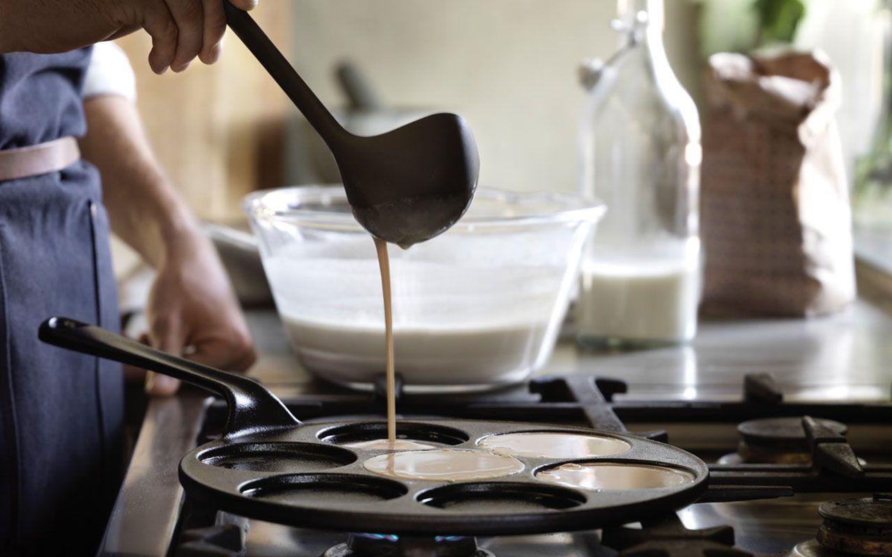 A VARDAGEN blini/pancake pan and a man pouring batter into it.