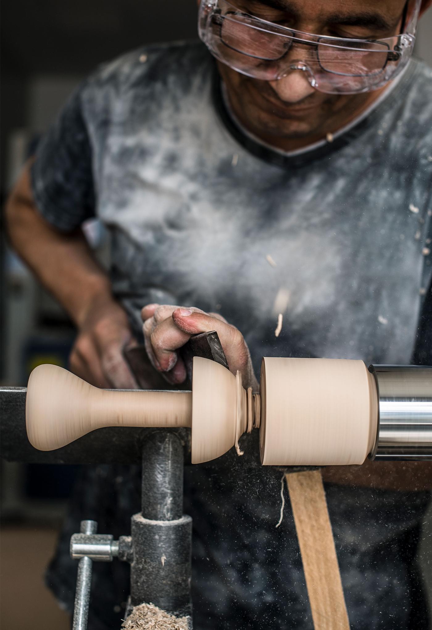 Dan Virgil turns wood on a lathe at a factory in Rumania.