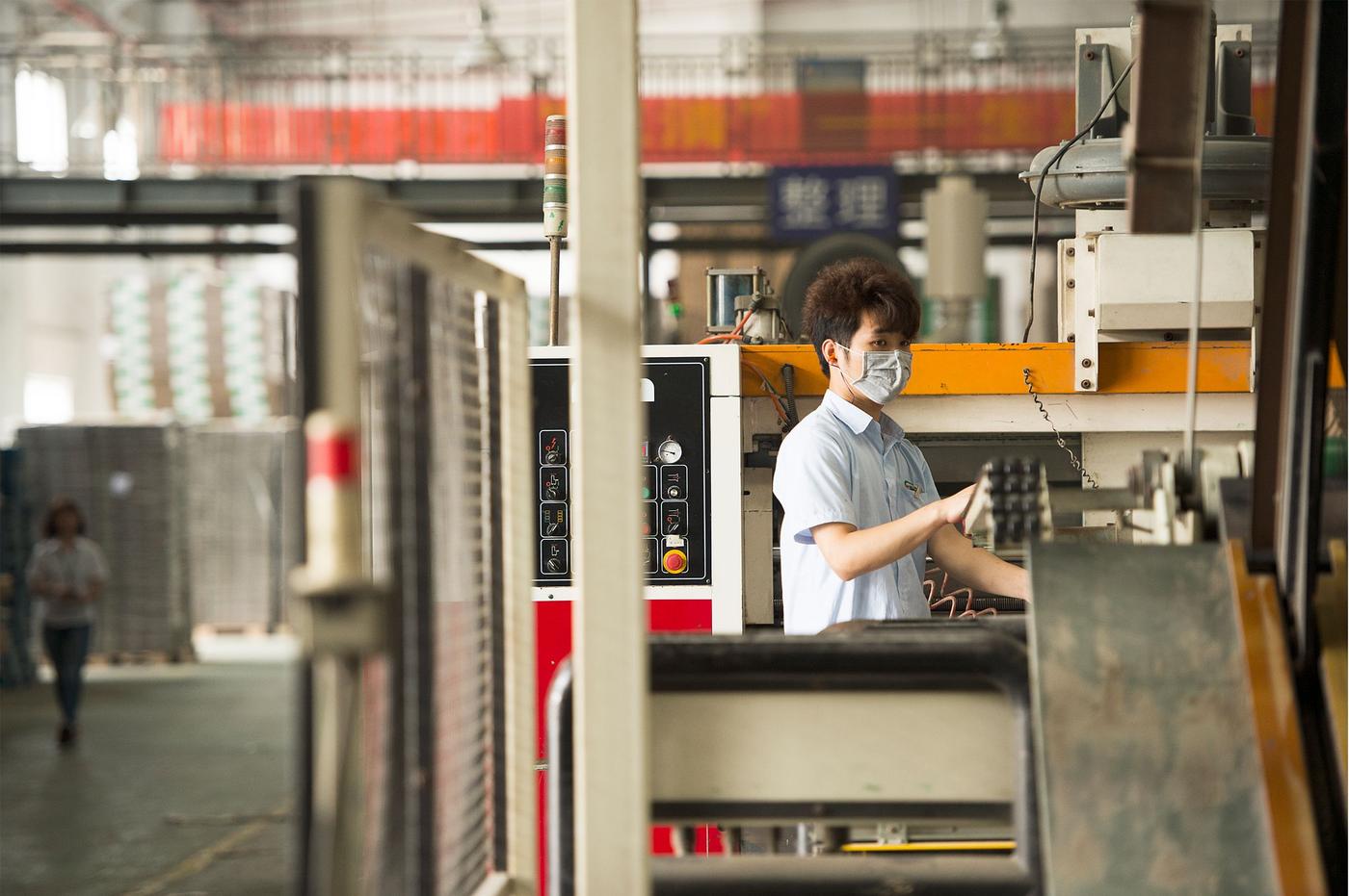 A factory worker operating a printing machine. 