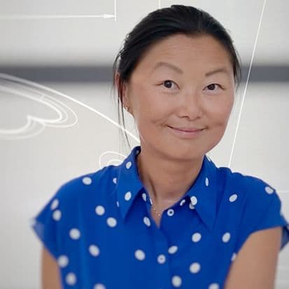 Portrait of Bonnie Yu wearing a blue shirt with white polka dots.